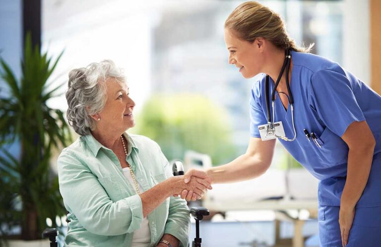 A caregiver gently assisting an older adult with daily grooming in a bright, comfortable room.